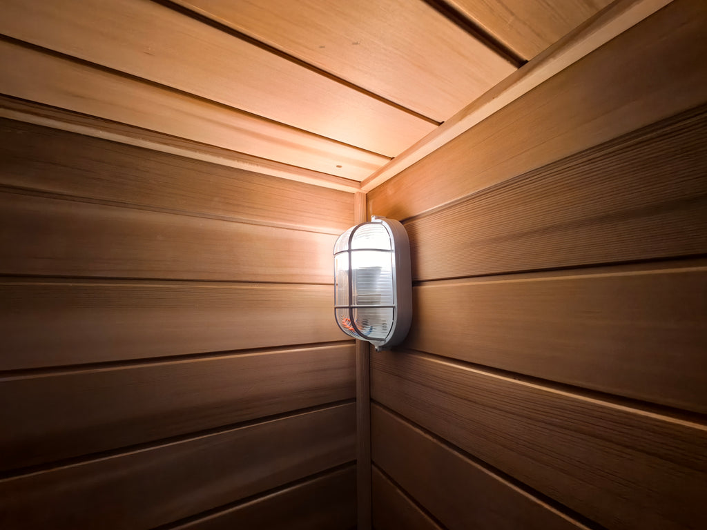 A modern - designed bathroom cedar sauna with a square fir cube shape, heated by an electric furnace.